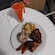 A plate of food with chicken, plantains, rice, a salad, and a tropical drink on the side